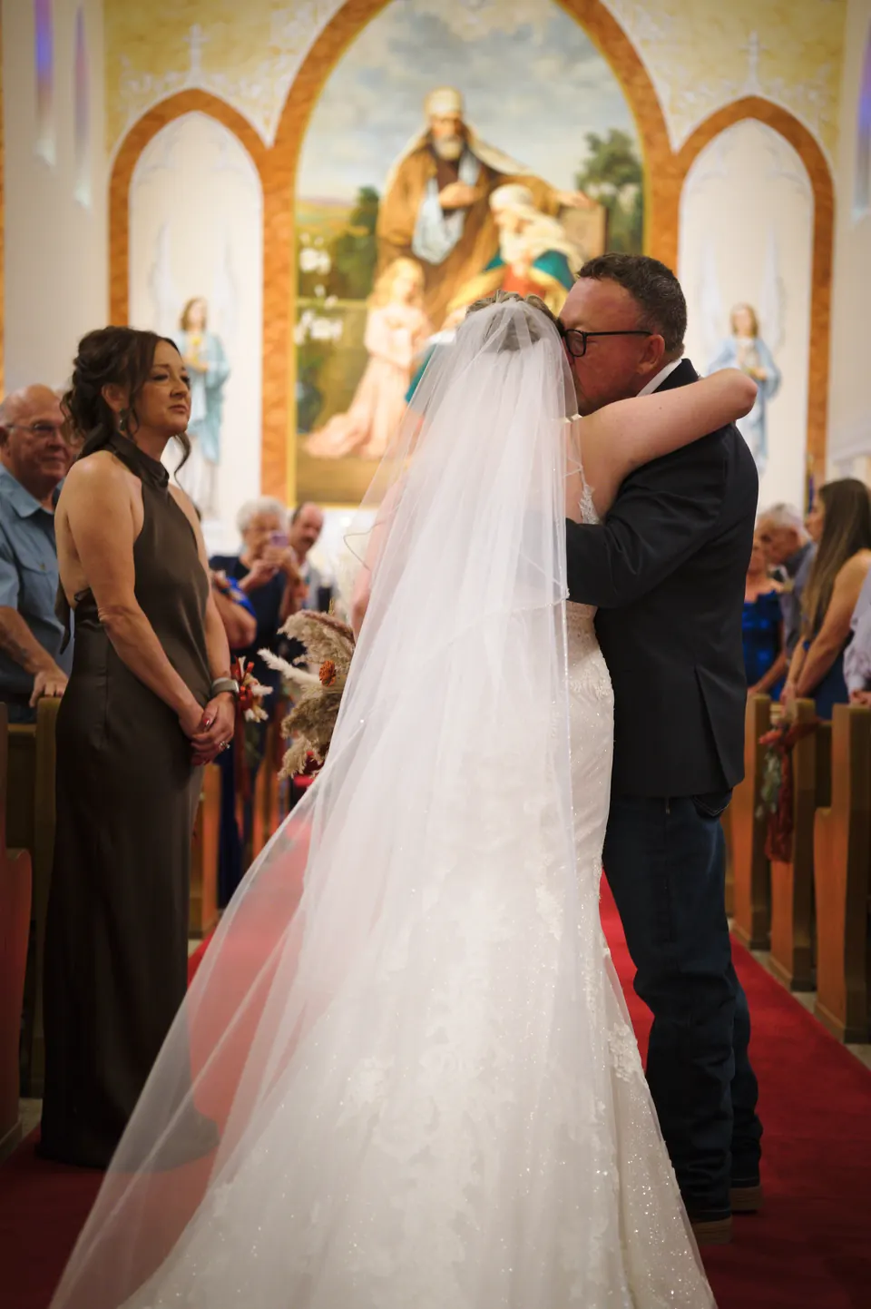 Momento emotivo al final del pasillo antes de la ceremonia en la Iglesia Católica St. Anne's en Kosciusko, Texas