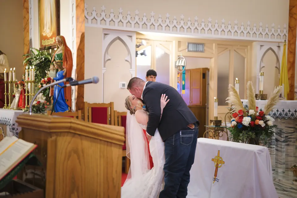 Primer beso de los novios en el altar en la Iglesia Católica St. Anne's en Kosciusko, Texas