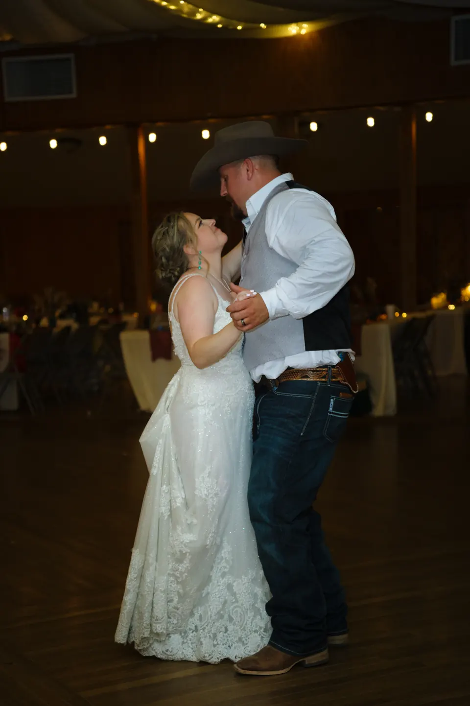 Novios abrazados en la pista durante su último baile en el Kosciusko Community Hall en Kosciusko, Texas