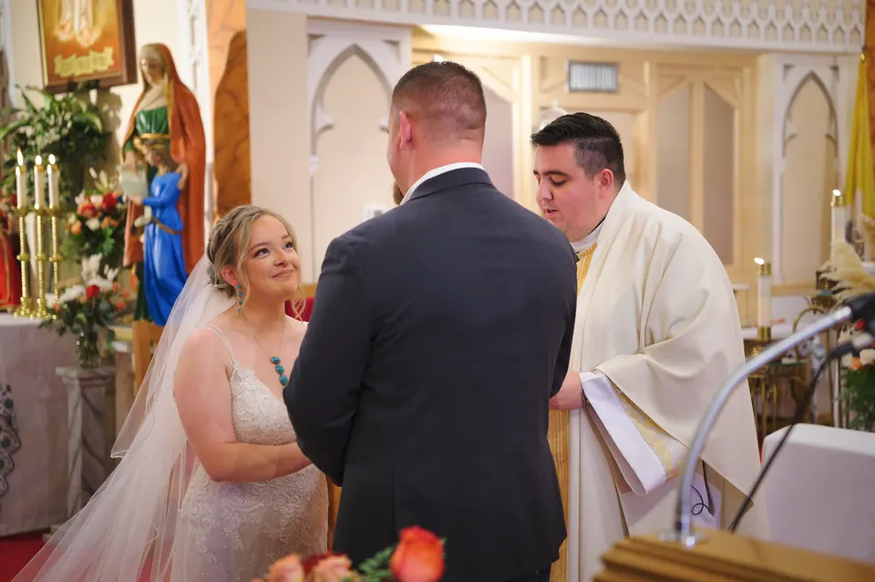 Novios frente al sacerdote durante sus votos en la Iglesia Católica St. Anne's en Kosciusko, Texas