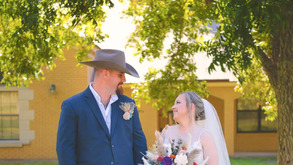 Bride and groom standing in the shade of oak trees on their Kosciusko, Texas wedding day