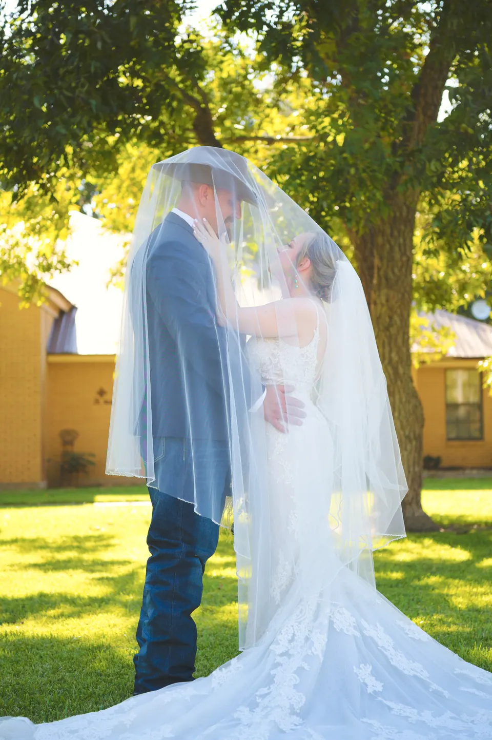 Couple sharing a quiet moment under the bride's veil in Kosciusko, Texas