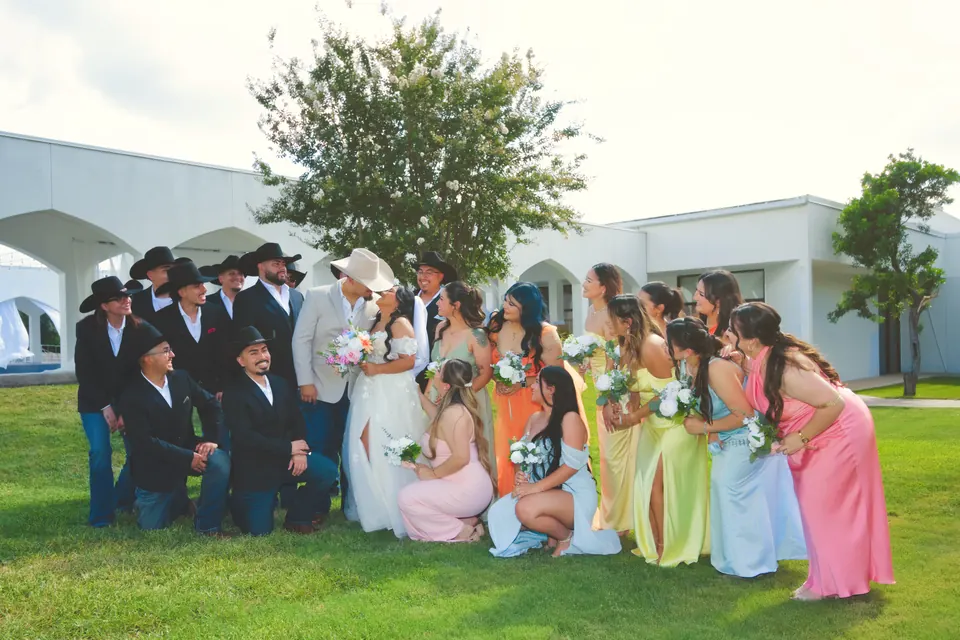 Bride and groom with groomsmen in cowboy hats and bridesmaids in bright colorful dresses in San Antonio