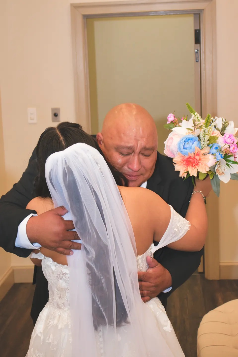 Bride's father hugging her tightly after the first look at the Phoenician Ballroom Event Center in San Antonio