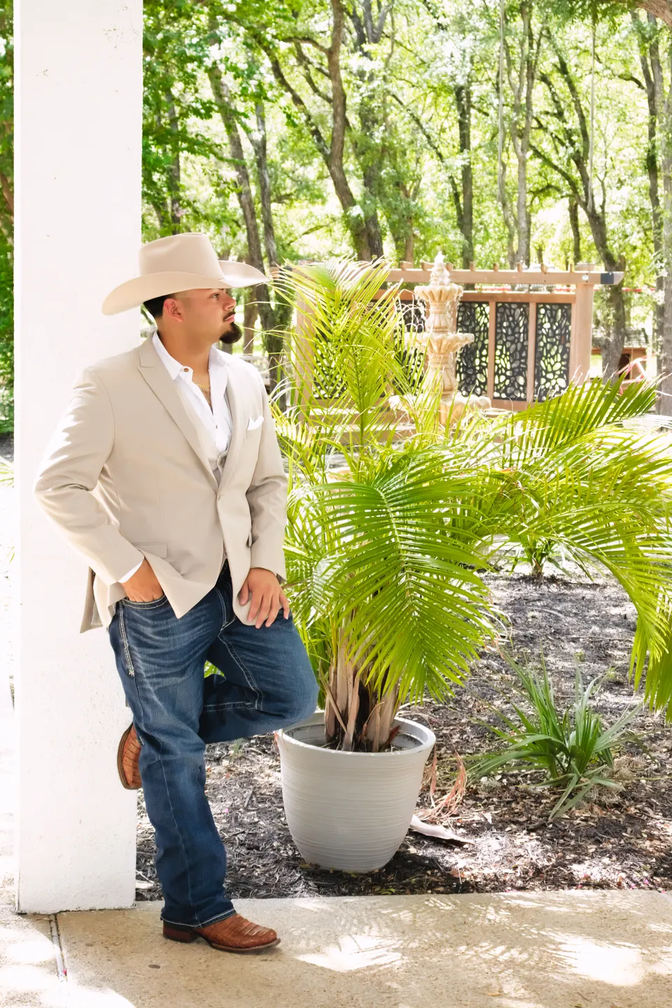 Groom in a white cowboy hat and tan blazer on his wedding day at the Phoenician Ballroom Event Center in San Antonio