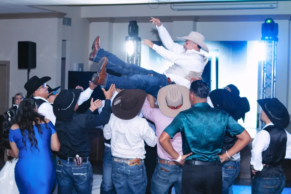 Groomsmen tossing the groom into the air on the dance floor at the Phoenician Ballroom Event Center in San Antonio