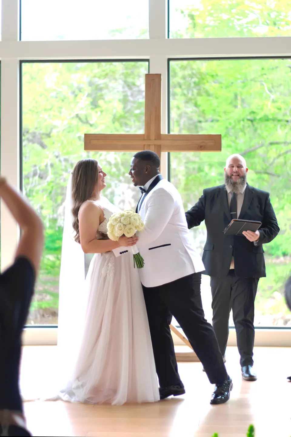 Couple laughing during their ceremony in front of the cross window at The Preserve at Canyon Lake