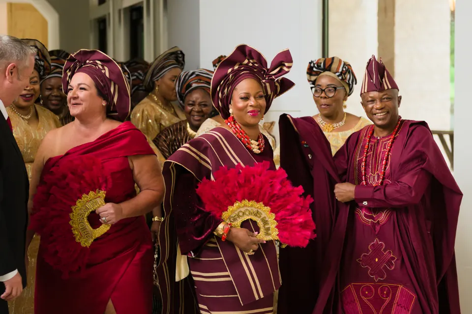 Family dancing into the reception in traditional Nigerian attire with red hand fans at The Preserve at Canyon Lake