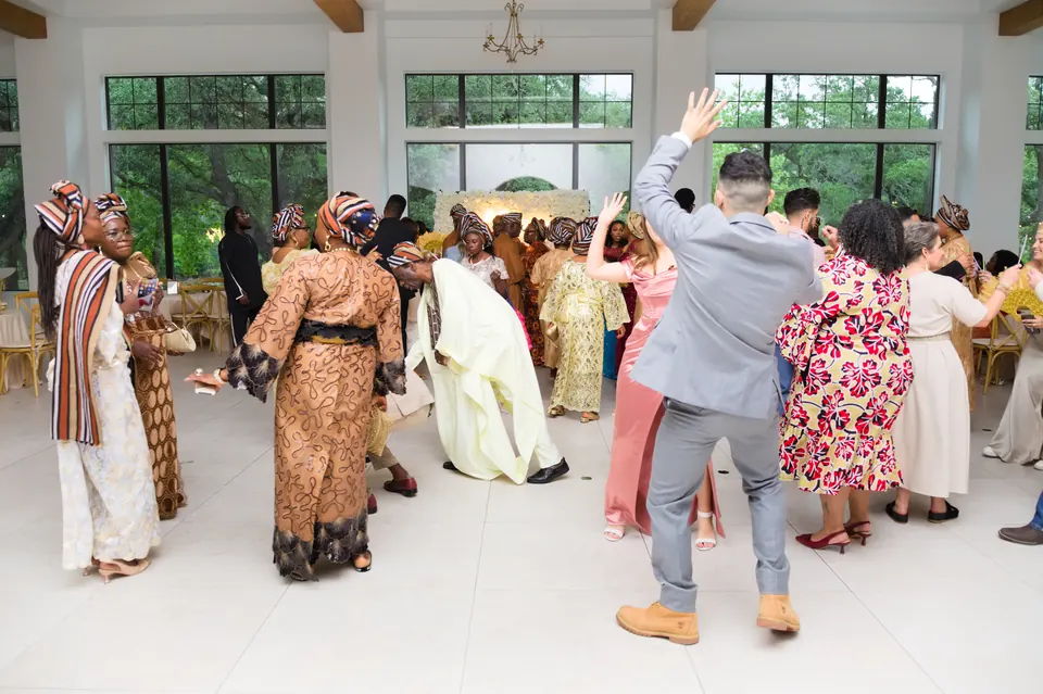Guests in colorful Nigerian attire dancing in the reception hall at The Preserve at Canyon Lake