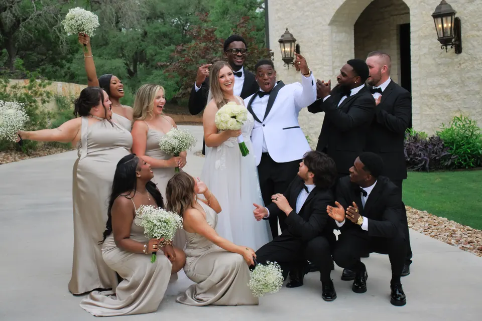 Bridesmaids and groomsmen cheering around the couple outside the chapel at The Preserve at Canyon Lake