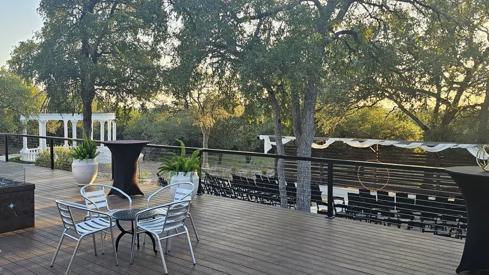Large wooden deck with cocktail tables overlooking the ceremony site and marble dome at Prima Vista in Wimberley, Texas