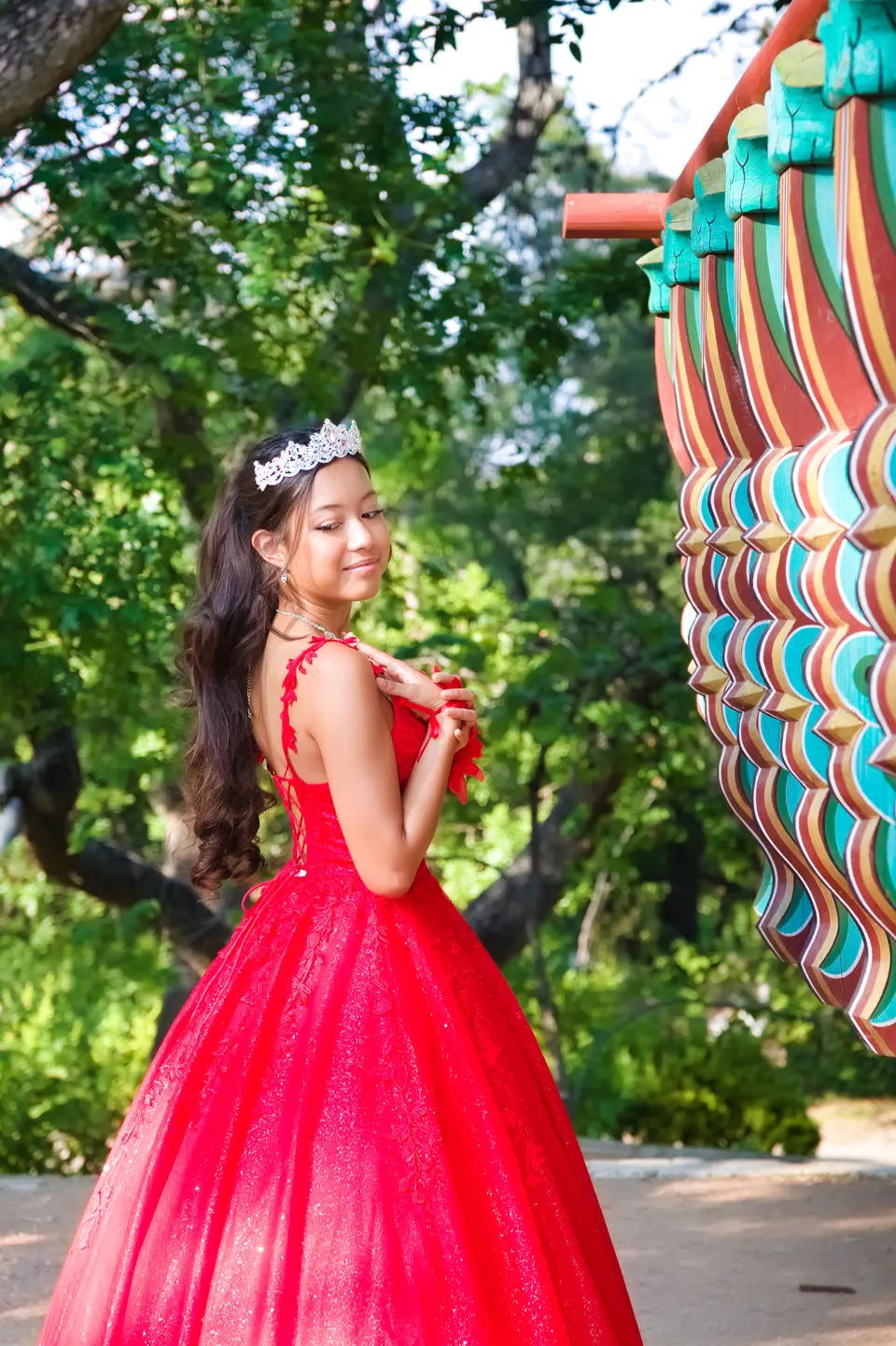 Quinceañera mirando sobre su hombro junto al pabellón coreano en Denman Estate Park, San Antonio