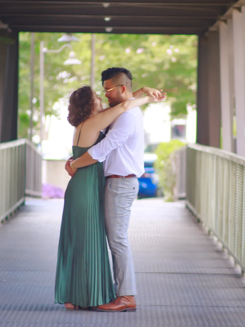 Couple embracing on a covered footbridge during their San Antonio engagement photos