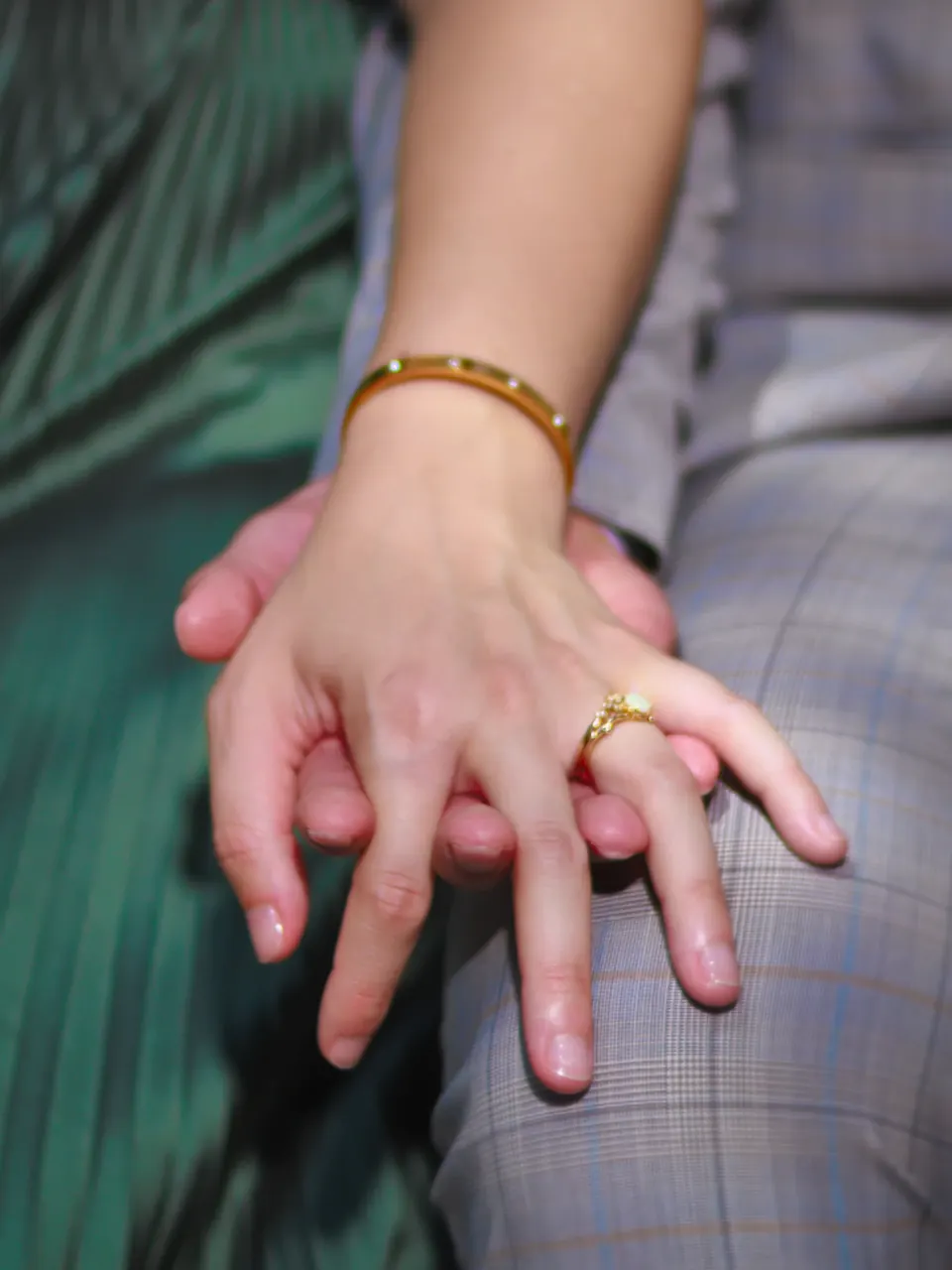 Close-up of the engagement ring as she rests her hand on her partner's knee