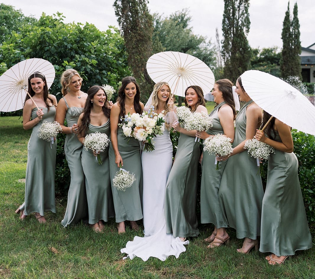 Bridesmaids with parasols in the gardens at Thistlewood Manor & Gardens